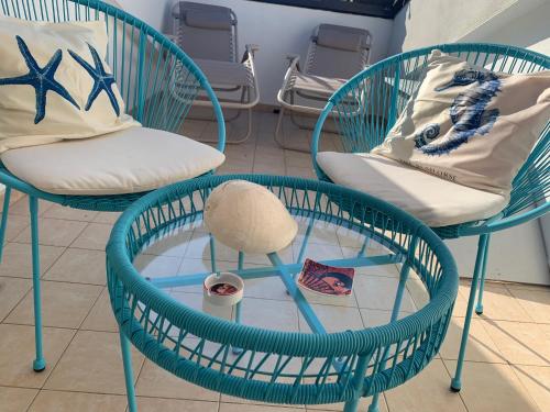 two chairs and a table with towels and a hat on them at Casa del sole in Nova Siri Marina