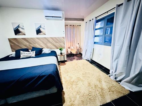 a bedroom with a blue bed and a window at Villa Seven in Guerra