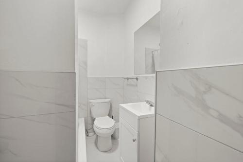 a white bathroom with a toilet and a sink at New Build Sunny 2 Bedroom Unit in Windsor
