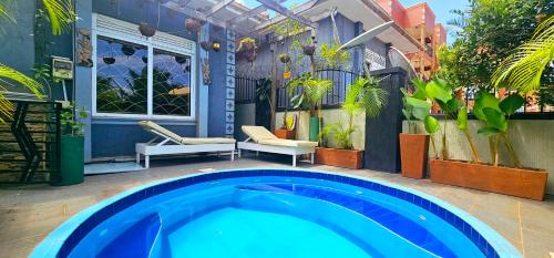 a large blue swimming pool in a patio with plants at Hidden Gem homes in Kampala
