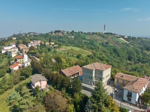 a village on a hill with houses and trees at Oltre Natura in Canneto Pavese