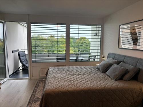 フリードリヒスハーフェンにあるBellevue FN, Appartement mit See- und Bergsichtの大きなベッドと大きな窓のある寝室