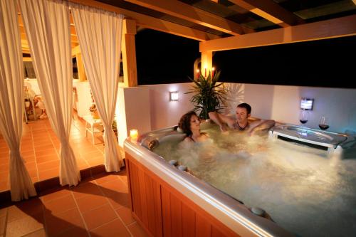 un uomo e una donna in una vasca da bagno in una stanza di WM GEDER Ferienwohnungen Villa Tanja a Lebring