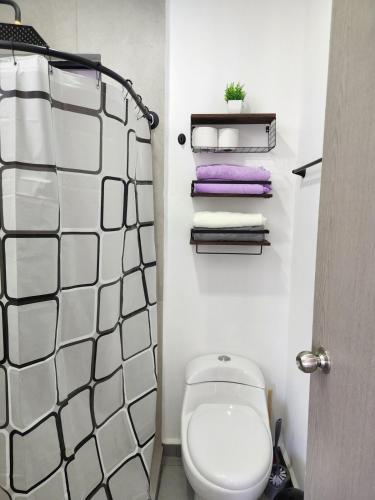 a bathroom with a toilet and some towels at Moderno y comodo Depto con terraza y alberca in Naranjo