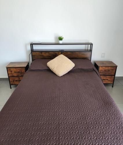 a large bed with a pillow on top of it at Moderno y comodo Depto con terraza y alberca in Naranjo