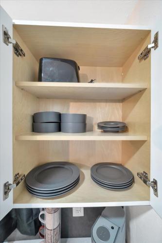 a cupboard with plates and dishes in it at Walk to Stadium, 2 Parking spots, Dog Park, BBQ in Tampa