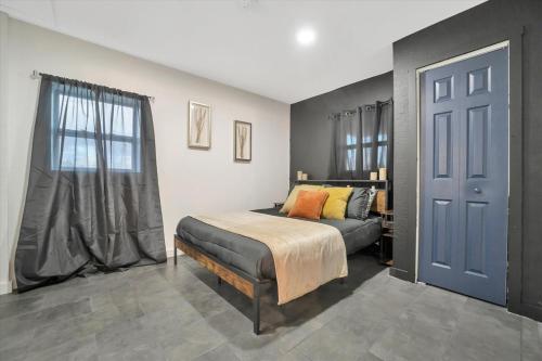 a bedroom with a bed and a window and a door at Walk to Stadium, 2 Parking spots, Dog Park, BBQ in Tampa