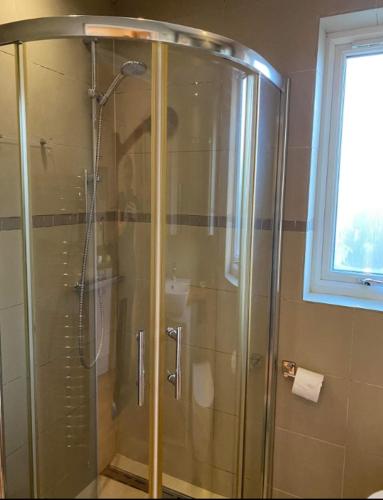 a shower with a glass door in a bathroom at Stunning Studio1, Banstead with free off st parking in Banstead