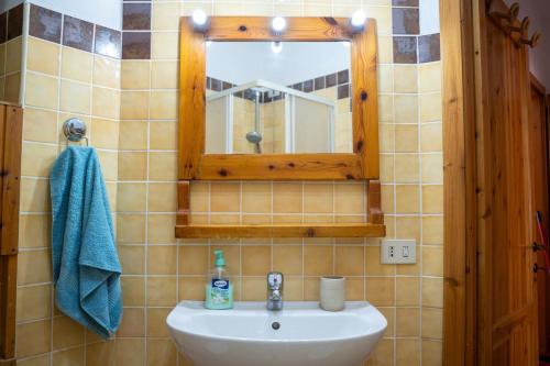 a bathroom with a sink and a mirror at Itadhome - White sail in Alghero