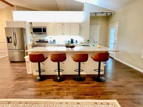 a kitchen with a counter and three bar stools at Three Bedroom House at Hamestring Creek in Fayetteville
