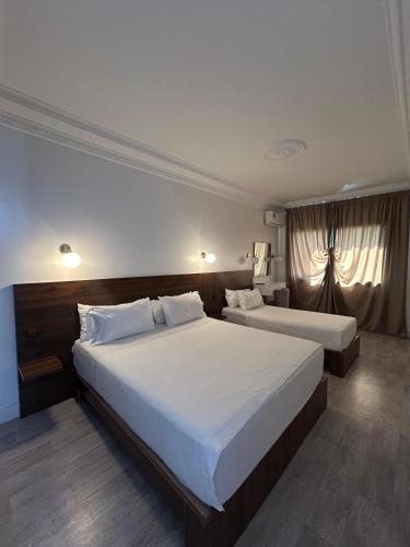 a hotel room with two beds with white sheets at Crystal hotel in Tangier