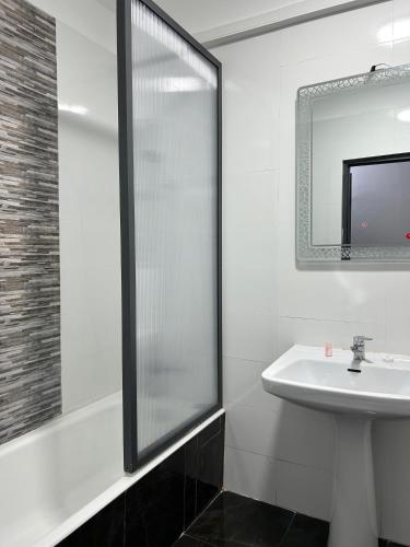 a white bathroom with a sink and a shower at Crystal hotel in Tangier