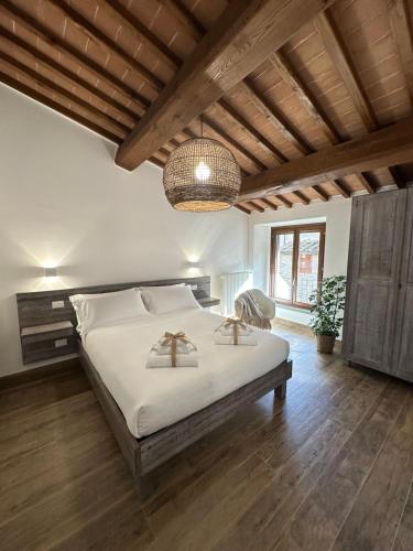 une chambre avec un grand lit et un lustre dans l'établissement Under The Tuscan Sun, à Arezzo