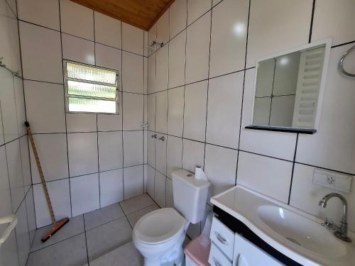 Sítio com 07 dormitórios, piscina e jogos LT0042 في Bairro dos Soares: حمام مع مرحاض ومغسلة ومرآة