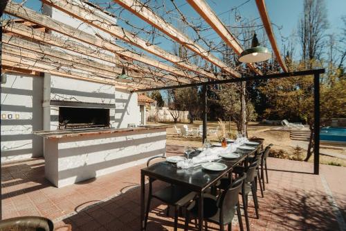un tavolo e sedie su un patio con camino di Hermosa Mansión-Parque inigualable-Pileta y AA a Chacras de Coria