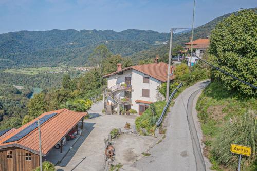 a house on a hill next to a road at Apartment Marta Slovenia Natures - Happy Rentals in Levpa