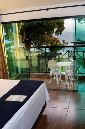 a bedroom with a balcony with a table and chairs at Chalés do Laurindo in Maciel