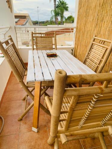 Una mesa y sillas de madera en un balcón. en casa Rituzza, en San Leone