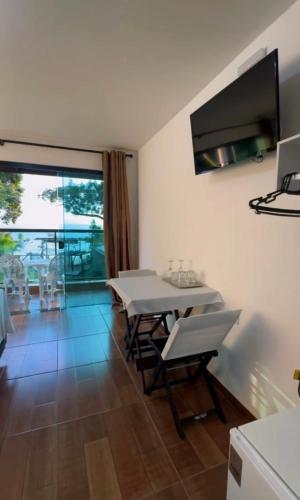 a dining room with a white table and chairs at Chalés do Laurindo in Maciel