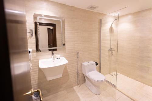 a bathroom with a toilet and a sink and a shower at فندق يقين مكة in Makkah