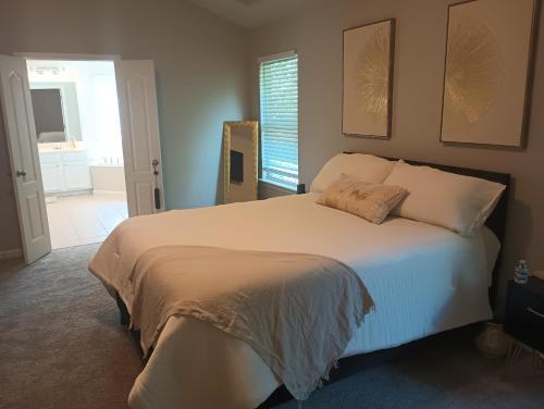 a bedroom with a large white bed with a window at The Serene in Between in Snellville