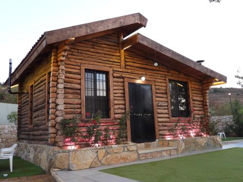 una baita di tronchi con porta nera di The Wood House a Maasser El Chouf