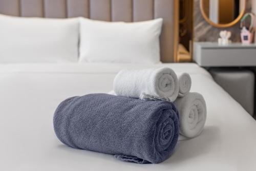 a pile of towels sitting on top of a bed at Bellevue Lagoon Premium Apart Hotel by TropicLook in Laguna Phuket