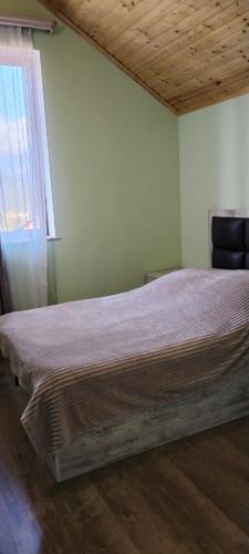a large bed in a room with a window at Тun Haus in Dilijan