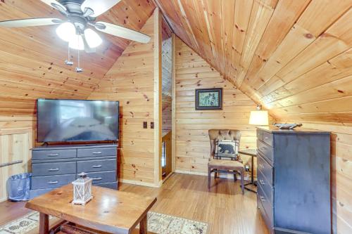a living room with a ceiling fan and a tv at Deck, Panoramic Views Serene Mineral Bluff Cabin! in Mineral Bluff