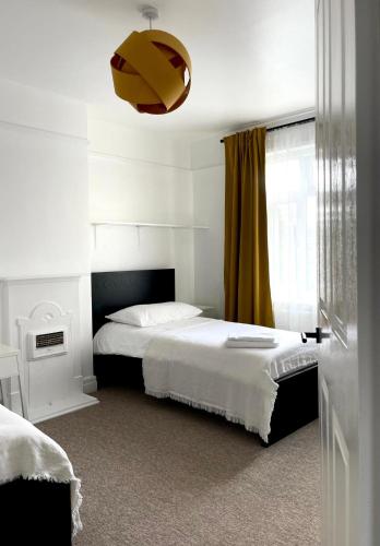 a bedroom with a bed and a yellow curtain at Spacious 4-Bed Home Near Cambridge City Centre in CBG