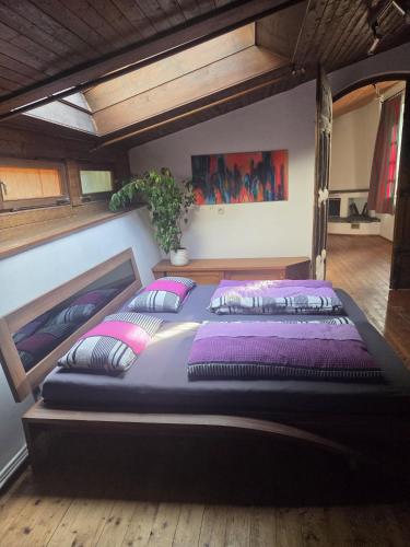 a bedroom with a large bed with purple sheets and pillows at Künstlerhaus Herrsching am Ammersee in Herrsching am Ammersee