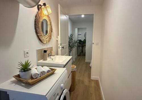 a white bathroom with a sink and a mirror at Fleur Bohème - Hypercentre République - Parking in Le Mans