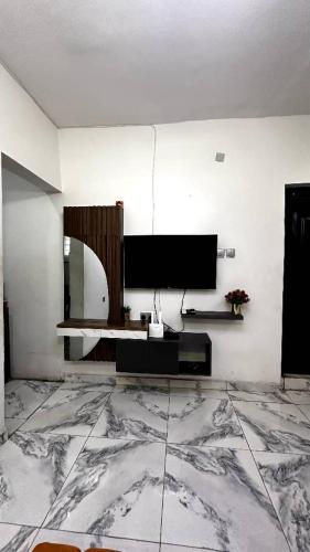 a living room with a television and a marble floor at Tami's Apartment 2 in Lagos