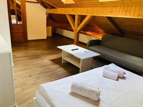 a room with a bed and a couch and a table at Pensiunea Agroturistica Cerna, Vaideeni - Polovragi in Vaideeni