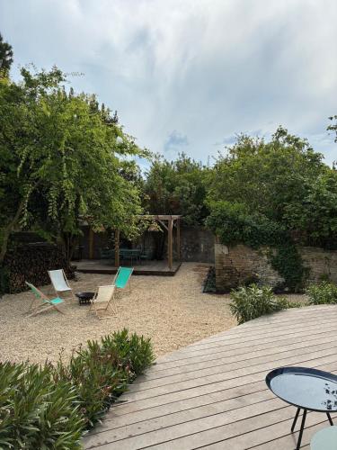 a patio with chairs and a table and a table and chairs at La Playita in Le Château-dʼOléron