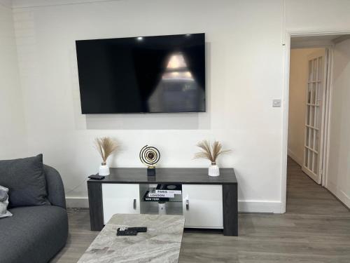 un soggiorno con un tavolo e una TV a parete di Eugino Properties a Stifford
