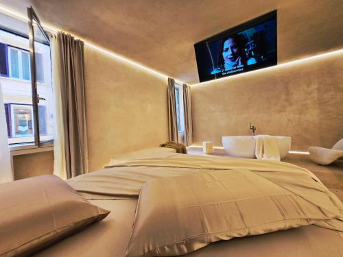 a bedroom with a bed with a tv on the wall at DUNE at Spanish Steps Luxury Apartment-Suite in Rome