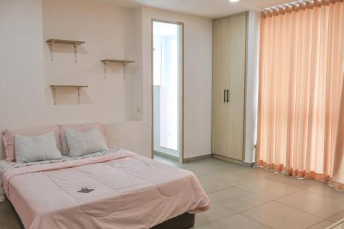 une chambre avec un grand lit avec une couverture rose dans l'établissement Espacioso Apto Moderno! Excelente Ubicación Norte de Barranquilla, à Barranquilla