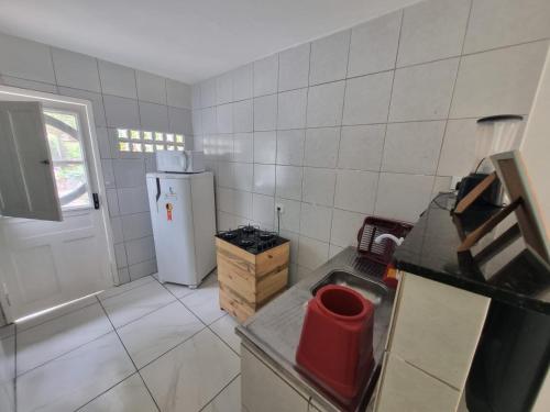a small kitchen with a sink and a refrigerator at Pousada Veruschka Santiago in Maragogi