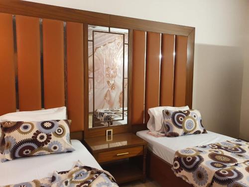 a small room with two beds and a mirror at Guest House By Imperial DHA in Karachi