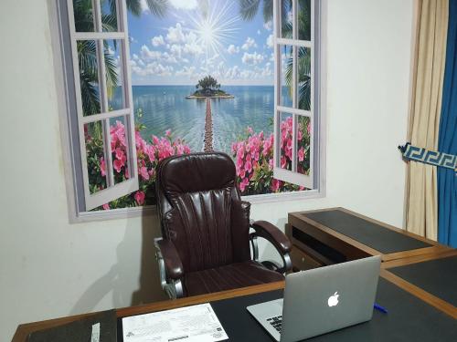 a desk with a computer and a chair in front of a window at Guest House By Imperial DHA in Karachi