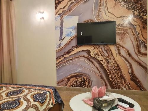 a room with a bed and a tv on a wall at Guest House By Imperial DHA in Karachi