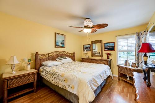 Un dormitorio con una cama y un ventilador de techo. en Extended Stay in Estero Townhome with Lake Views!, en Estero
