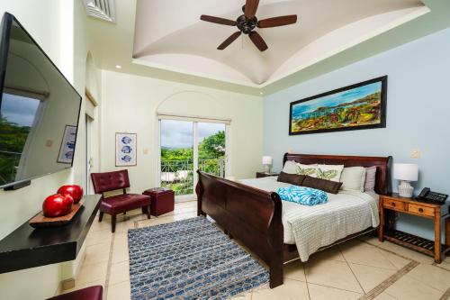 a bedroom with a bed and a ceiling fan at Oceanview In Town Huge Pool Beach Acss in Tamarindo