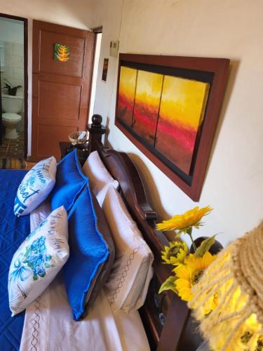 a couch with pillows and a painting on the wall at AQUI ESTOY BIEN in Barichara
