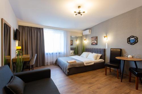 a hotel room with a bed and a living room at Сучасна студія в центрі - Харківська набережна 3-8 in Kharkiv