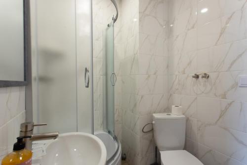 a bathroom with a shower and a toilet and a sink at Сучасна студія в центрі - Харківська набережна 3-8 in Kharkiv