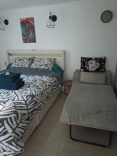 a bedroom with a bed and a bench in it at L'océane in Saint-Maurice-de-Beynost