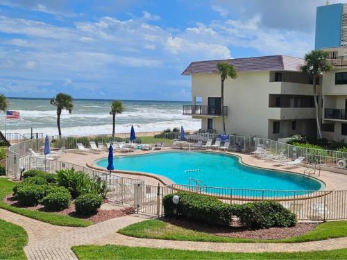 a resort with a swimming pool and the ocean at Barry Palm in Ormond Beach