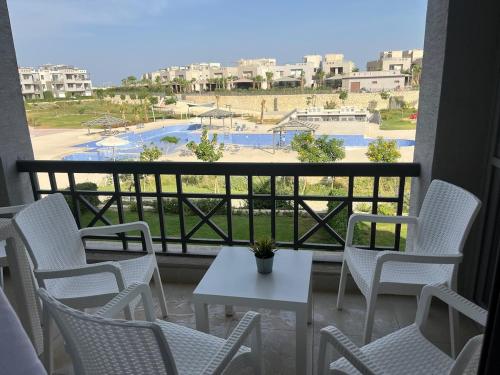 a balcony with chairs and a table and a view at 1BDR chalet on direct swimming pool Einbay in Ain Sokhna